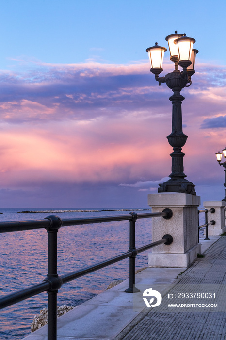 日落时的巴里海滨。古老的原始路灯，令人惊叹的天空颜色。海景。