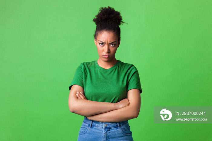 Portrait of offended black woman standing with folded arms