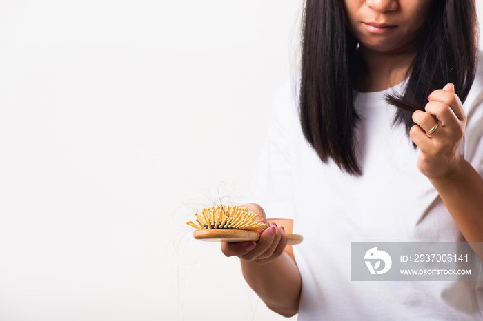 Asian woman unhappy weak hair her hold hairbrush with damaged long loss hair in the comb brush on ha