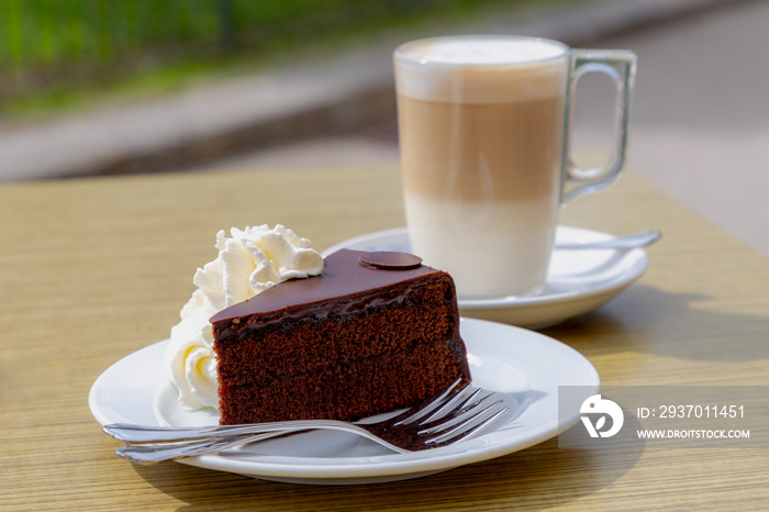 桌上的原装Sacher Torte配搅打奶油，咖啡很晚，蛋糕由致密的蛋糕组成