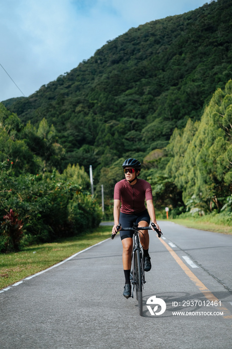 A young female cyclist riding her gravel bike in the mountains.