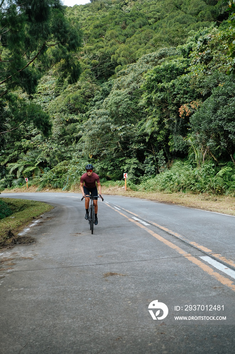 A young female cyclist riding her gravel bike in the mountains.