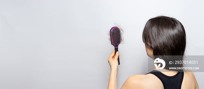 The girl is holding a hairbrush with lost hair. Hair loss, care and treatment. Trichologist, trichol