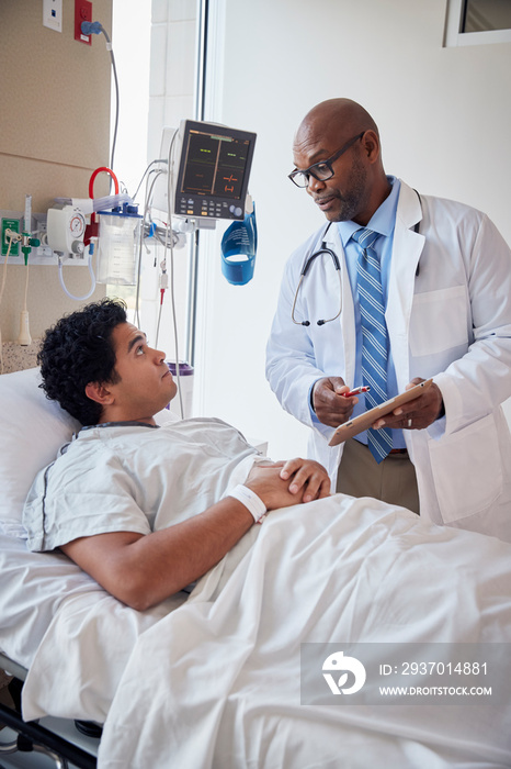 Patient talking to doctor while lying a hospital bed