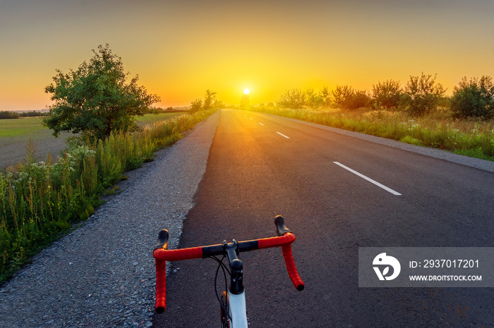 骑自行车上路。骑自行车欣赏美丽的日落风景