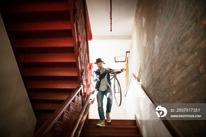 Man walking up stairs with bicycle