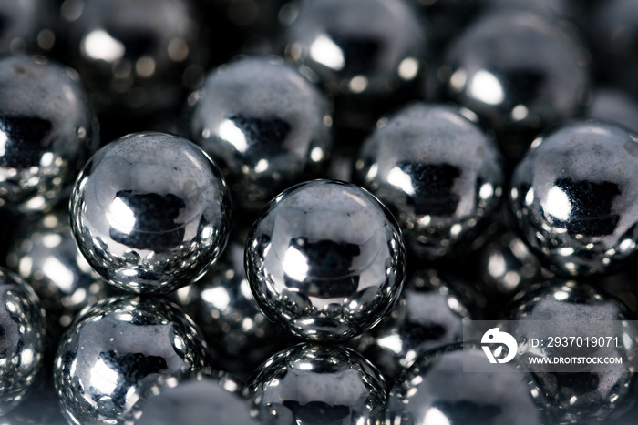 Metal balls with shiny reflections. The balls are arranged next to each other, the structure is made