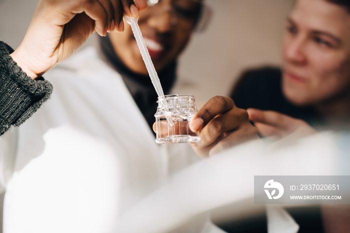 Male and female students experimenting in chemistry class at university