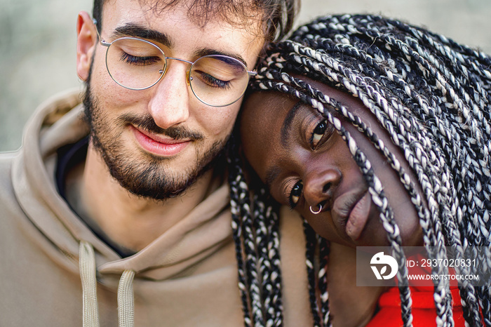 Affectionate biracial couple sitting outdoors - close up shot