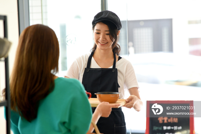 配膳をする女性店員