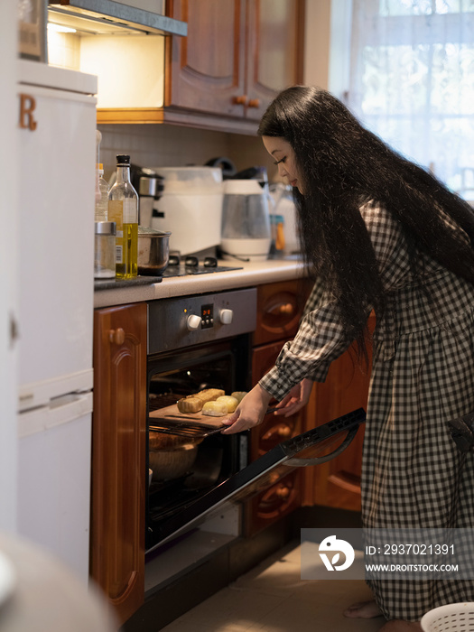 女人把月饼放进烤箱