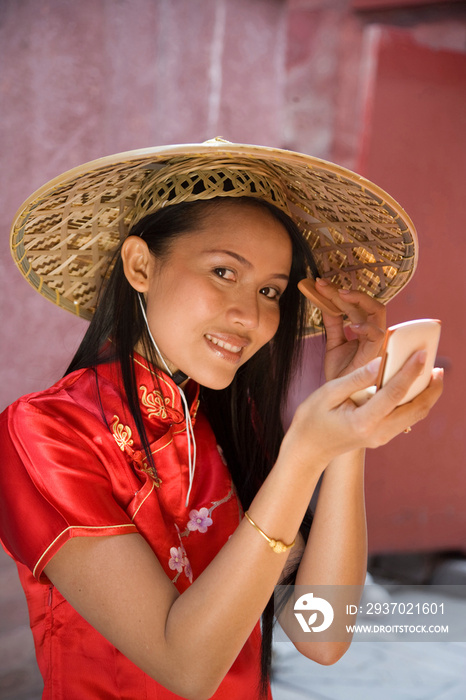 Portrait of woman in chinese dress, putting on make up, Beijing, China