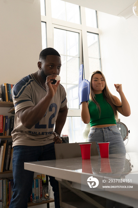 Friends�playing beer pong at home party