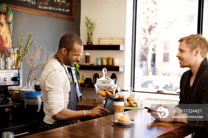 Customer buying coffee from barista