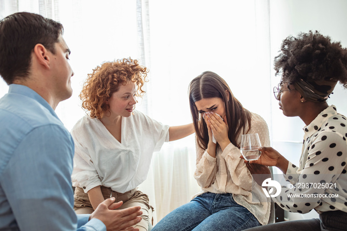 A diverse group of adults sit in a circle in their chairs and listen to and sympathize with each oth