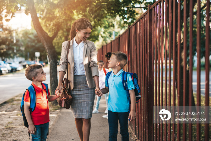 Mother taking her sons to school.