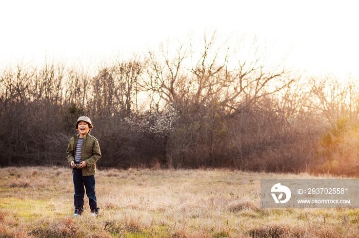 Boy (6-7) standing in meadow