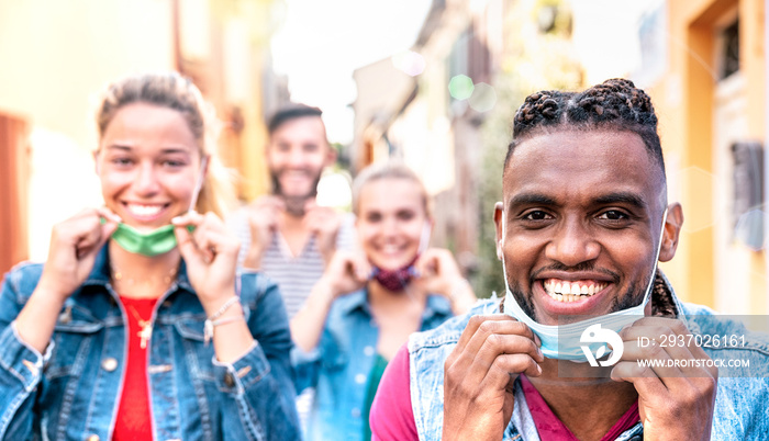 Multiracial friends with face mask after lockdown reopen - New normal friendship concept with guys a