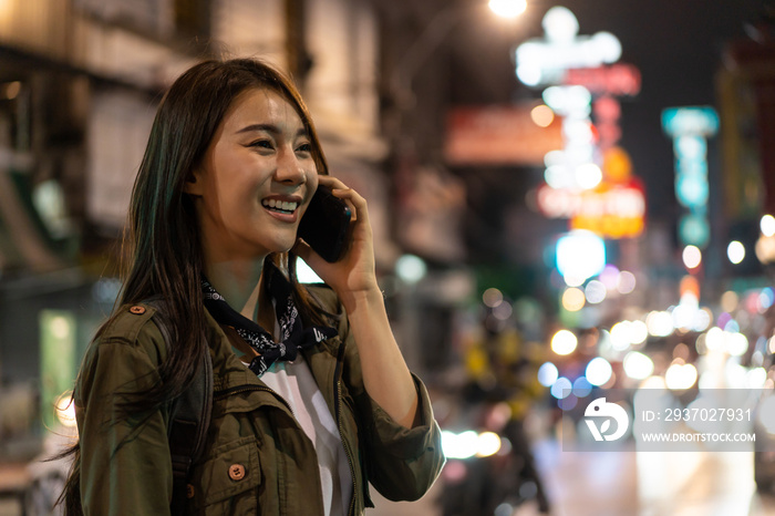 Asian attractive woman backpacker talking on mobile phone walk in city.