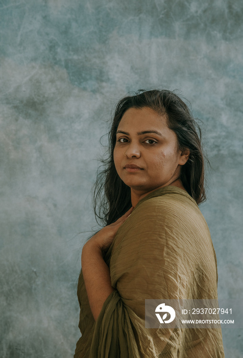 Portrait of an East Indian woman looking at camera with hand on chest