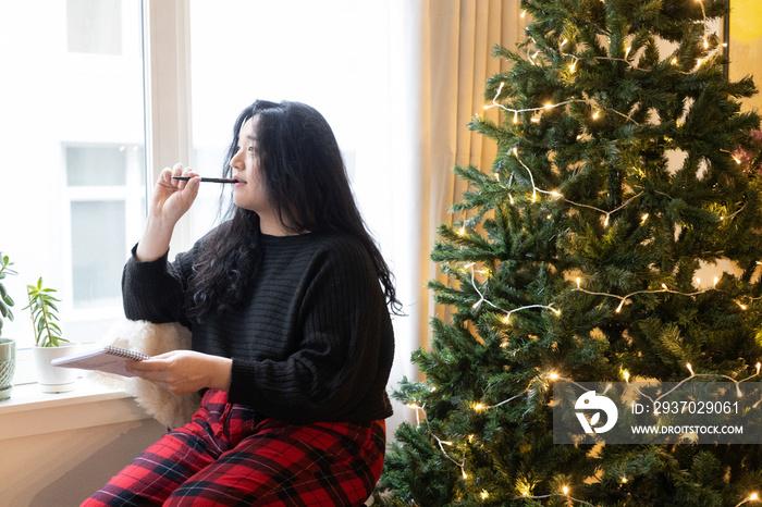 Asian American trans woman decorating for the holidays.