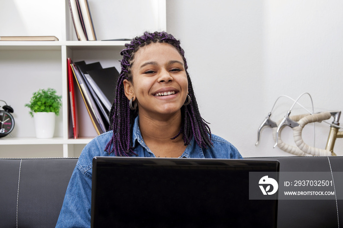 female young Latin American with computer in house