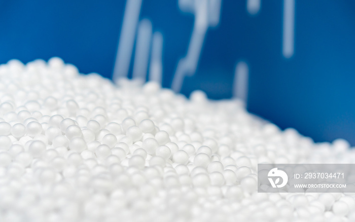 white polystyrene foam beads ball drop from Styrofoam machine for fragile stuff packaging box on blu
