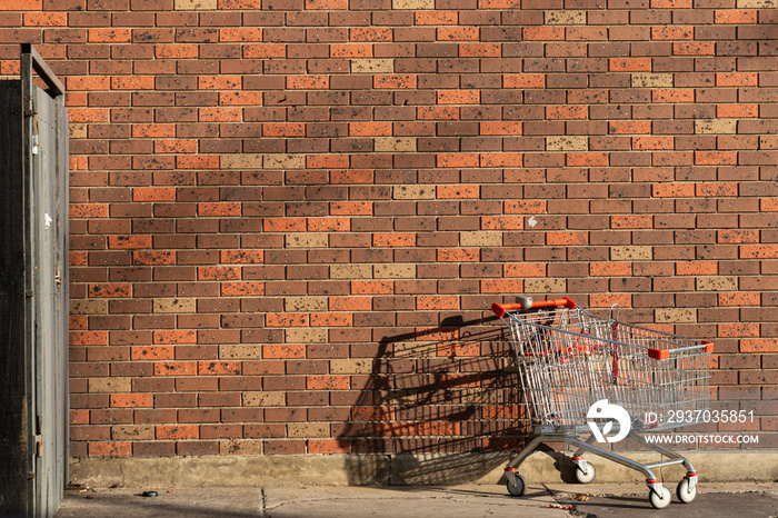 红色砖墙上留下的废弃购物车。