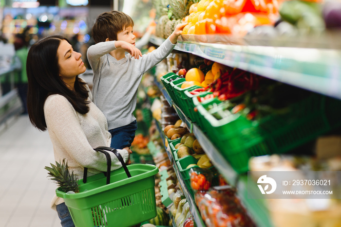 年轻妈妈和她的小男孩在超市。健康饮食理念