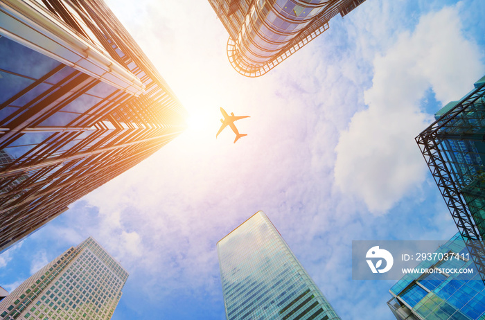 Airplane flying over modern business skyscrapers. Transport, travel.