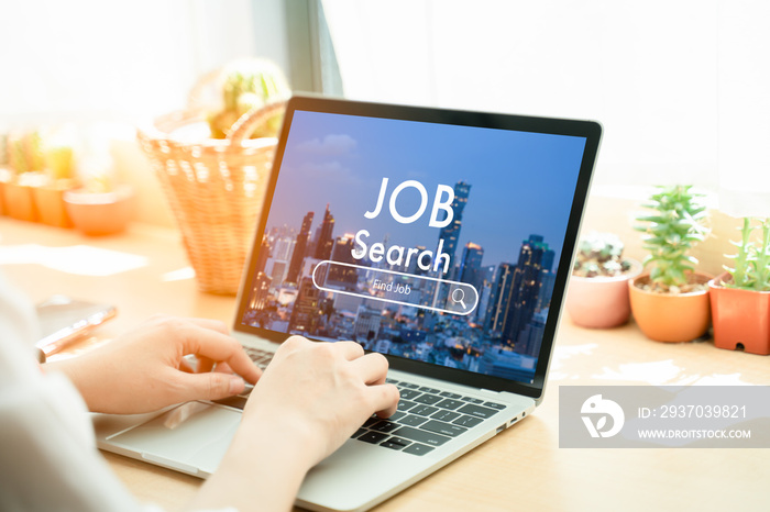 Back view of woman browsing work opportunities online using job search computer app after being laid