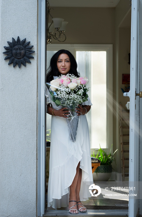 Woman holding flowers by the doorway