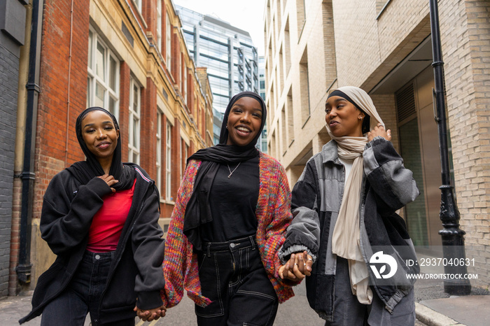 Three young women wearing�hijabs�walking in city