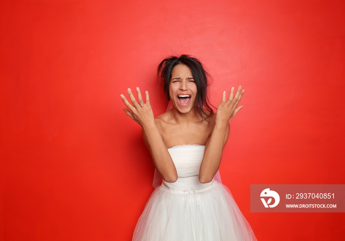 Screaming young bride on color background