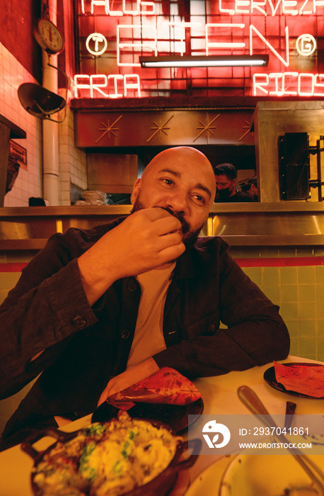 Man eating food in Mexican restaurant