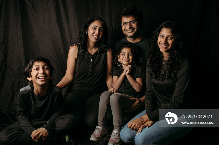 A Blended Family portrait with everyone dressed in black and looking at the camera