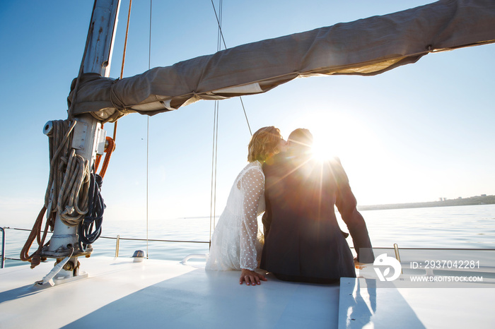 Beautiful wedding couple on yacht at wedding day outdoors in the sea. Beautiful elegant  bride in a 