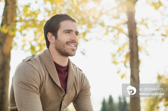 Thoughtful young man smiling in park