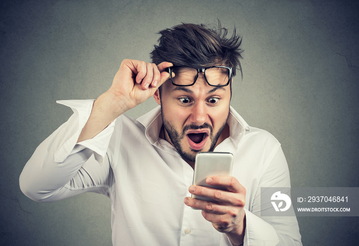 Shocked man reading news on smartphone