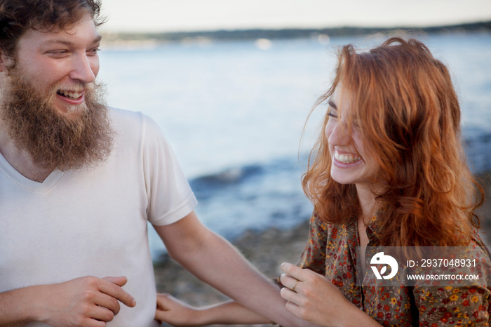 Smiling young couple standing by lake