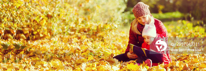 母亲在秋季公园教女儿，母亲教女儿读书。