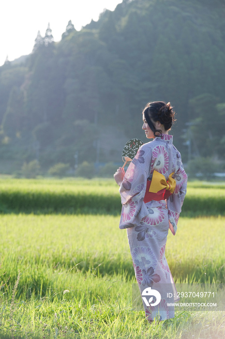 草地上穿着和服的日本年轻女子