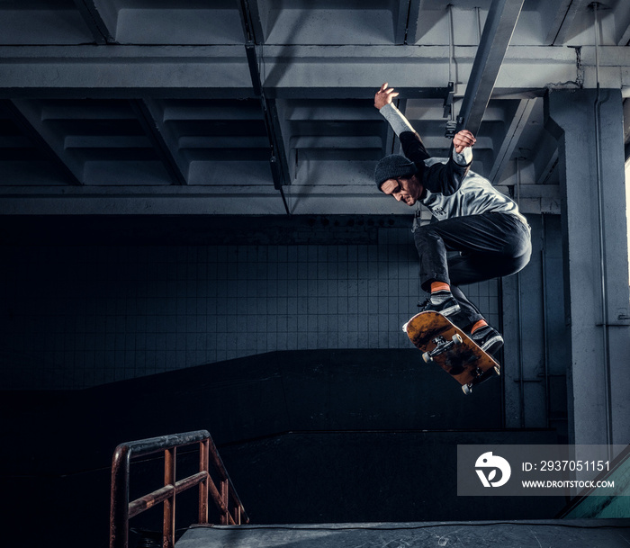 Skateboarder jumping high on mini ramp at skate park indoor.