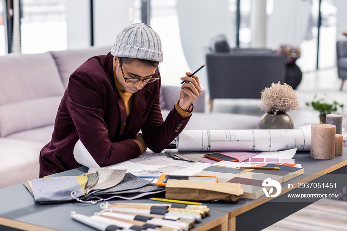 Undistracted calm adult male worker engaging in drawings making