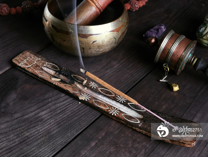 incense stick burning on a wooden stand