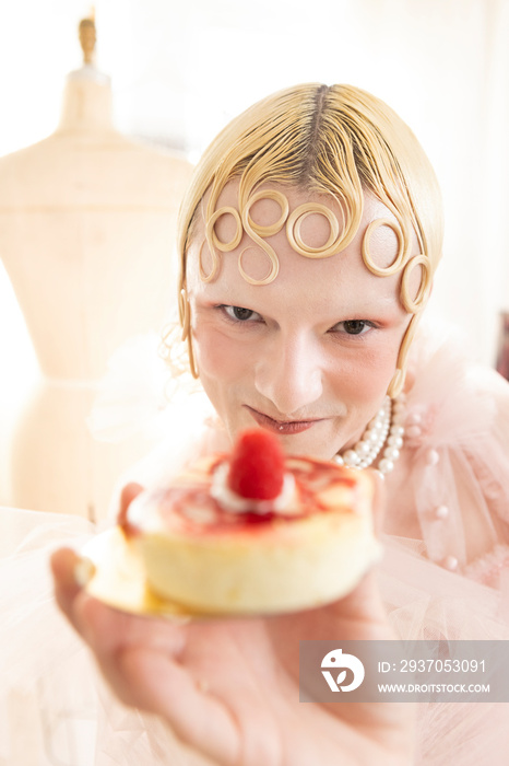 close up of non-binary hispanic person playfully eating a pretty dessert