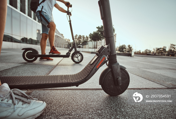 Young couple are making interesting composition from their scooters while posing for photographer.