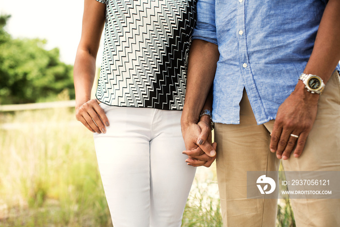 Mid-section of couple holding hands