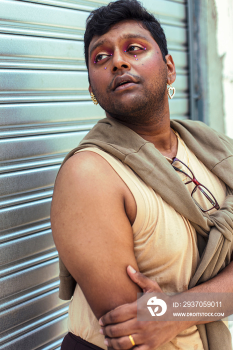 portrait of dark skinned Indian man in Malaysia, with theatrical facial expressions, in the alleyway