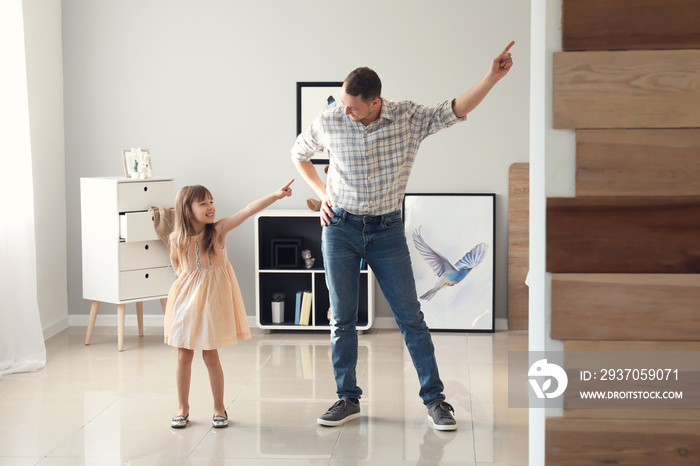 Father and his cute little daughter dancing at home